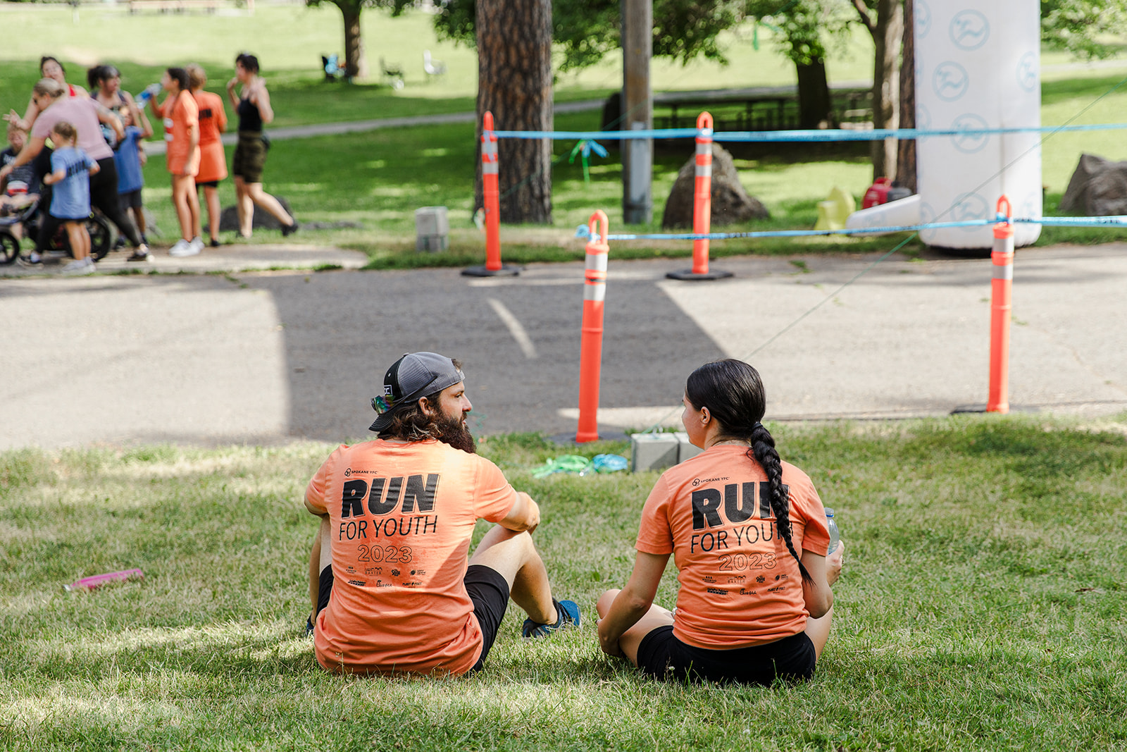 two people sitting in the grass talking